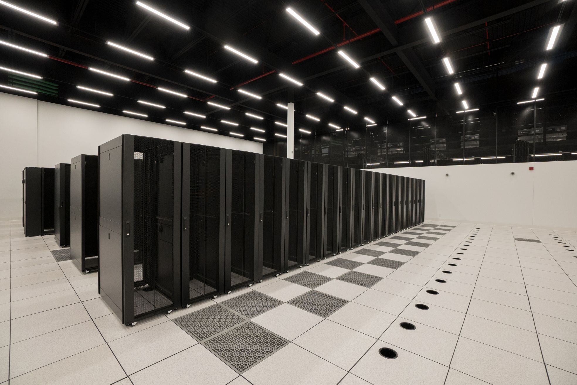 A photograph of the data hall at eStruxture MTL-5 data center. The photograph shows rows of black cabinet racks.